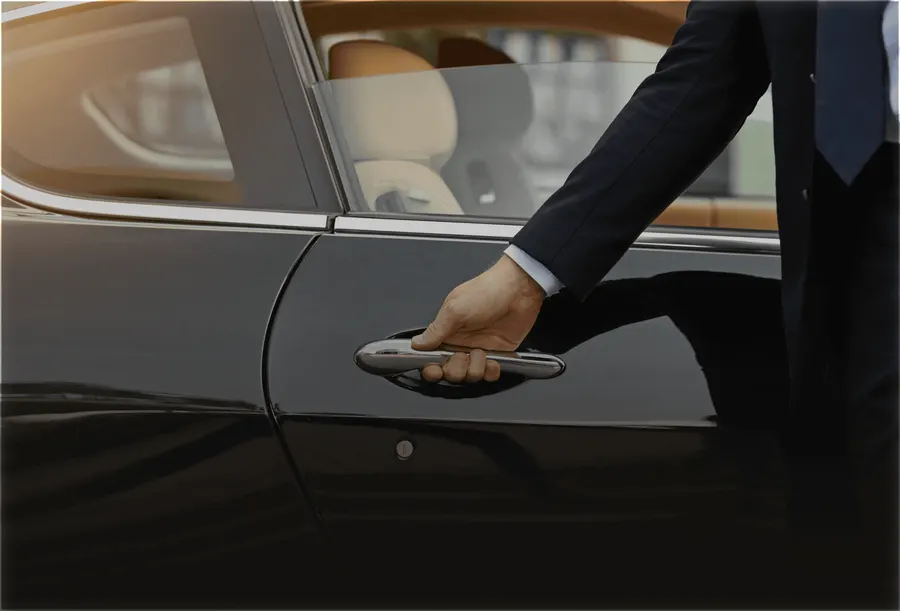 Chauffeur öffnet die Tür einer schwarzen Limousine